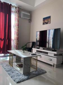 a living room with a table and a tv at 1BR Suite in Manhattan Heights Tower D in Manila