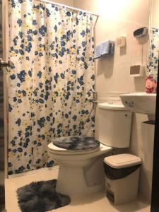 a bathroom with a toilet and a shower curtain at 1BR Suite in Manhattan Heights Tower D in Manila