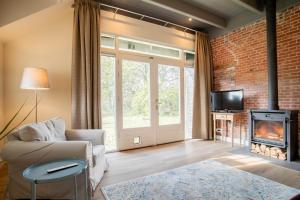 a living room with a brick wall and a fireplace at De Lindenhoeve in Valthe