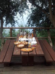 Agririfugio Molini في كامولي: طاولة نزهة خشبية عليها بيتزا ومشروبات