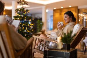 een vrouw die in een stoel een kop koffie drinkt bij Hotel Seevilla Wolfgangsee in St. Wolfgang