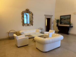 a living room with two white couches and a mirror at Grand Hotel Dei Castelli in Sestri Levante