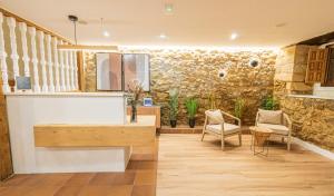 a room with a counter and chairs and a stone wall at Hotel BESTPRICE Santillana in Santillana del Mar