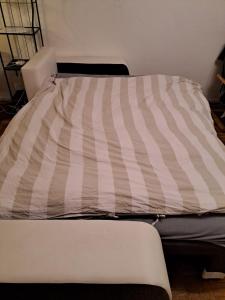 a bed with a striped comforter in a room at Münster City Apartment in Münster