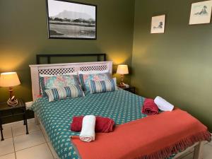 a bedroom with a bed with a red blanket at Carmel Huys in Cape Town