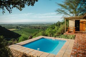 a swimming pool on top of a hill with a view at Hitgeheim Country Lodge in Addo