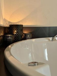 a white sink in a bathroom with black tiles at Le Colonne B&b in Ercolano