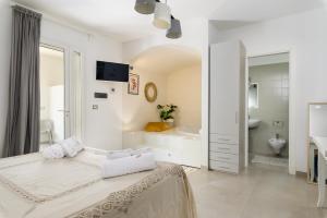 un bagno bianco con letto, vasca e lavandino di MandorloCarrubo's suite a Ostuni
