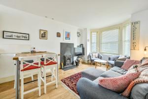 a living room with a couch and a fireplace at Captain's House Looe in Looe