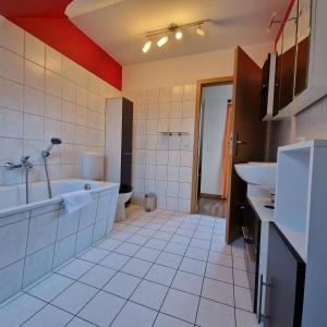 y baño con bañera, aseo y lavamanos. en DM Hotes & Apartments - Apartment Dosborn 5-9, en Dingelstädt