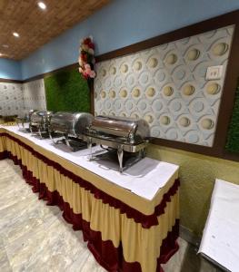 a long table in a restaurant with a row of seats at Hotel Corporate Inn, Patna in Khagaul