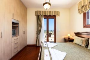 a bedroom with a bed and a tv and a window at Newly Renovated Villa 4 Seasons with BBQ, private pool, ping pong and football table in Viranepiskopí +60 photos
