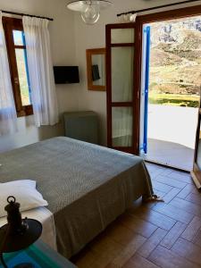 a bedroom with a bed and a sliding glass door at Theoreion in Tholária