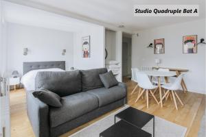 uma sala de estar com um sofá e um quarto em Apparts de l'Oncle Louis em Versailles
