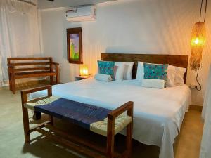 a bedroom with a large white bed with blue pillows at Vito Hotel Boutique in Taganga