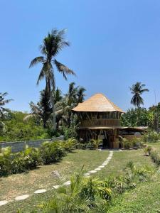 un kiosque dans un champ avec un palmier dans l'établissement Villa Dwipa, à Blahbatu