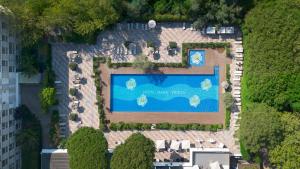 vista sul tetto di una piscina in un cortile di Villa Regina - MarePineta Resort a Milano Marittima