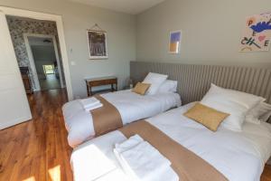 Habitación de hotel con 2 camas con sábanas blancas en Petit jouandeou, 