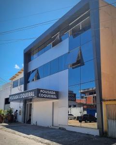 a large glass building with a sign on it at Pousada Coqueiral in Aracruz