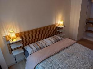 een slaapkamer met een bed met twee lampjes aan de muur bij La bella Olivia in Trieste