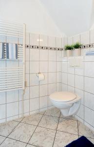 La salle de bains est pourvue de toilettes et de plantes murales. dans l'établissement Ferienwohnung Harms, à Esens