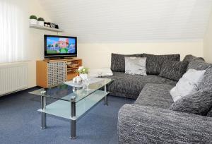 - un salon avec un canapé et une télévision dans l'établissement Ferienwohnung Harms, à Esens