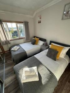 ein Hotelzimmer mit 2 Betten und einem Sofa in der Unterkunft Comfortable and Spacious Home - Free Parking in Bedford