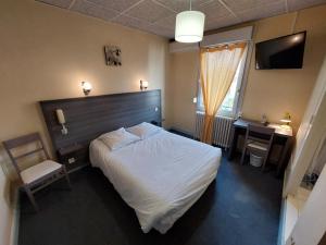 a bedroom with a bed and a chair and a desk at Logis Hotels - Le Saint Clément - Hotel Restaurant in Saint-Médard-de-Guizières
