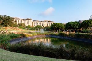 a pond in a park in front of a building at Glorystar The Millennial Umhlanga in Durban