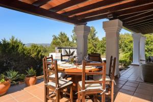 a patio with a wooden table and chairs on a deck at Villa Marlis in Port des Torrent