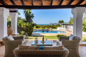 a patio with a table and chairs and a swimming pool at Villa Marlis in Port des Torrent