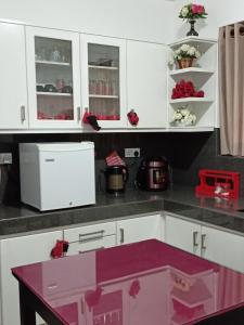 kuchnia z białymi szafkami i różową wyspą w obiekcie Serene Villa w mieście Kadugannawa