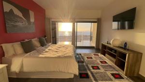 a bedroom with a bed and a view of the ocean at DIVINE SANDS in Langstrand