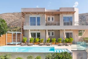 a villa with a swimming pool and a resort at Almiriki Chios Rooms & Apartments in Líthion