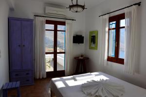 1 dormitorio con cama blanca y ventana en Theoreion, en Tholária