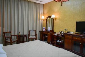 a hotel room with a bed and a television at Hotel Feride in Vinnytsya