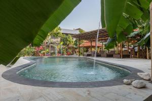 een zwembad met een fontein midden op een patio bij Sanur Lodge in Sanur