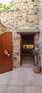 a stone building with a garage with a table at Kagiampakis Concept Residences in Avdou