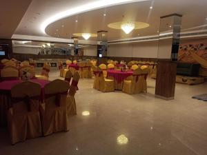 een feestzaal met rode tafels en gele stoelen bij The City Life Hotel in Zirakpur