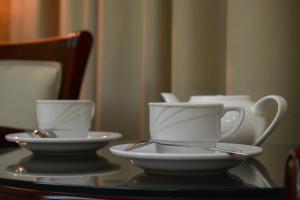 two white cups and saucers on a table at Hotel Feride in Vinnytsya