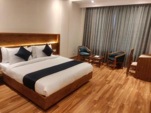 Habitación de hotel con cama, mesa y sillas en The City Life Hotel, en Zirakpur