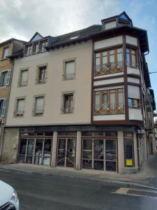 a tall building with windows on a street at Idéal , Plein centre-ville tout confort in Espalion