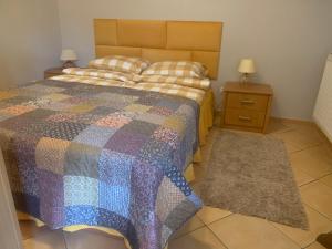 a bedroom with a bed with a colorful quilt at Zielony Domek in Karpacz