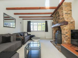 a living room with a couch and a fireplace at Pass the Keys Spacious Home in Picturesque Village of Wraysbury in Wraysbury