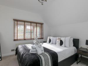 - une chambre avec un grand lit et une fenêtre dans l'établissement Pass the Keys Spacious Home in Picturesque Village of Wraysbury, à Wraysbury