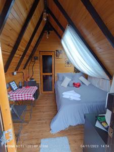 a attic bedroom with two beds and a table at Glamping refugio Gaia in Paipa