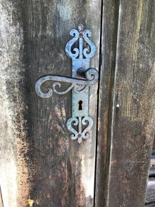 a metal door knocker on a wooden door at Unikt 1800-tals boende i hjärtat av Dalarna in Våmhus