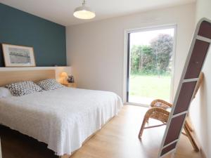 a bedroom with a bed and a window and a ladder at Le gite de la battere in Saubusse