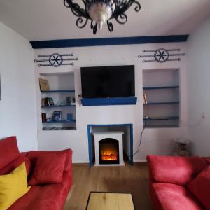 een woonkamer met een open haard en een televisie bij Casa Mox en la Sierra de las Nieves, Paraíso del Senderismo in Yunquera
