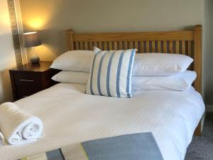 Bett mit weißer Bettwäsche und Kissen in der Unterkunft 5 Shore Street in Donaghadee